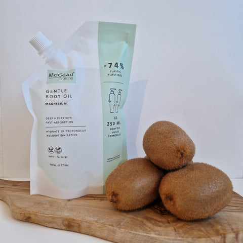 Tube of Mageau naturel magnesium Gentle Body Oil with kiwis on a wooden surface