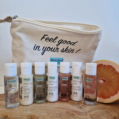 MaGéAu Naturel magnesium Cosmetic bag with 'Feel good in your skin!' text, containing skincare products on a wooden surface.