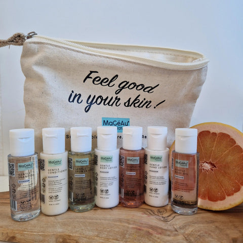 MaGéAu Naturel magnesium Cosmetic bag with 'Feel good in your skin!' text, containing skincare products on a wooden surface.
