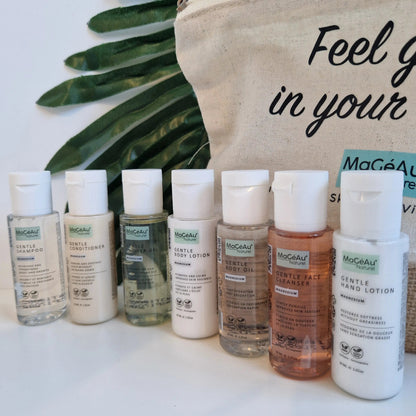 Row of MaGéAu Naturel skincare bottles with a beige bag and green leaves in the background