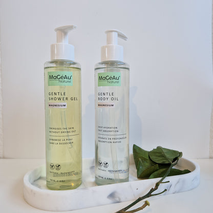 Two bottles of Mageau naturel magnesium  Gentle products on a white surface with green leaves.