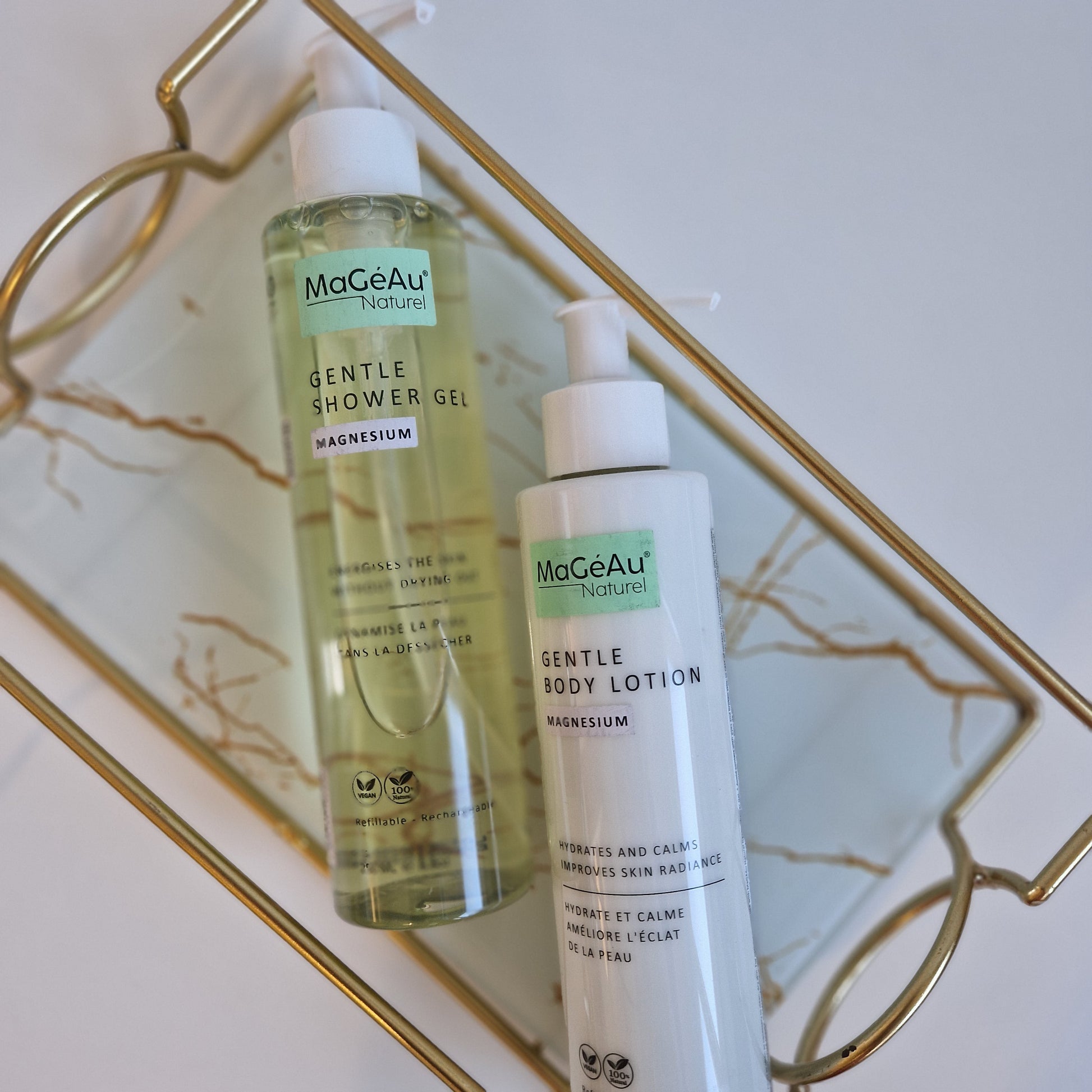 Three bottles of Mageau naturel magnesium skincare products on a decorative tray with a marble background.