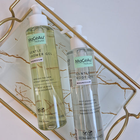 Two bottles of Mageau naturel magnesium  skincare products on a decorative tray with a marble pattern.